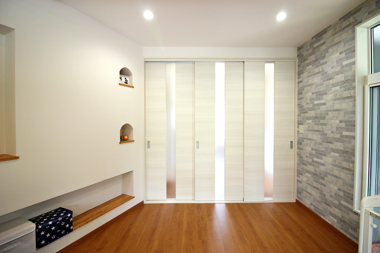 階段下から玄関方向へ。リビング入り口は麻の葉文様の組子建具。組子はヒノキとホオノキの2種 くふうイエタテ