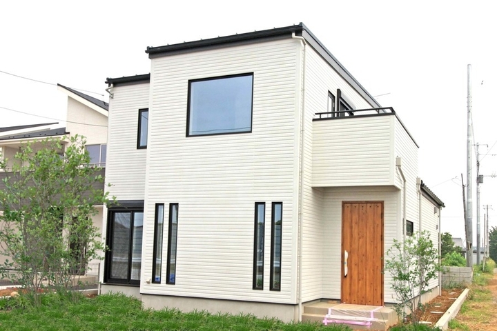 濃いグレーの外壁に木目が映える外観。玄関ポーチの階段を幅広くとり、格調高い雰囲気に住まいるコーポレーションわたしの住まい