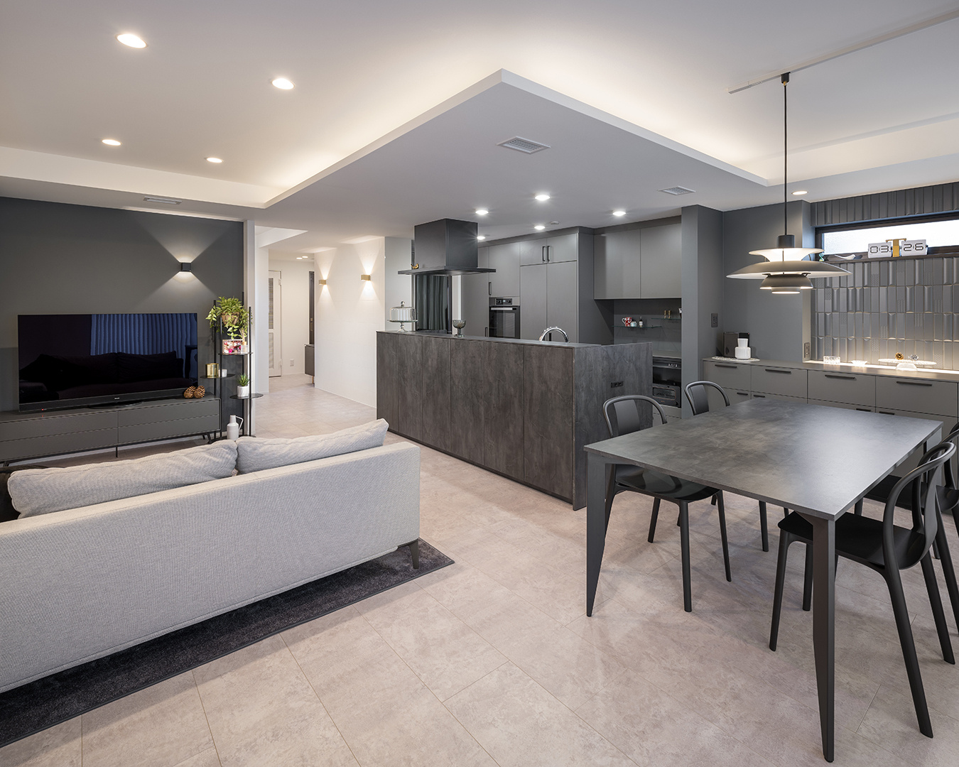 折り下げ天井のキッチンは、ライトグレイッシュの配色と木目のやさしさが融合し、居心地のいい場所に。お気に入りのペンダントライトや雑貨もマッチす