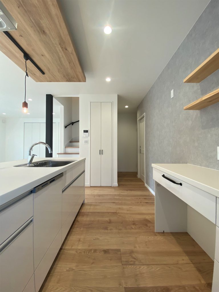 キッチンの天井に木目調のクロスを貼り、間接照明をビルトインしてニュアンスを出した。造作カウンターでは晩酌を楽しむこともあるそう。回遊性の高い