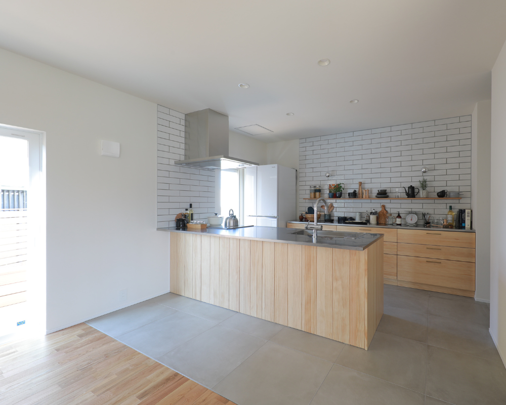 素材のスイッチ』 フローリングとモルタル床、 床材の違いでリビングとキッチンをゾーニング。 キッチン腰壁は古材のようなオークとプレーンなベニヤを張り分けました。素材の切り替えが楽しい、笑顔が集まるリビングです。nu_renovation nuリノベーション 設計事務所