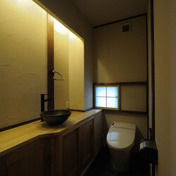 こだわりの和風トイレ網代天井にじゅらく壁。 檜のカウンターには、備前焼の手洗鉢をはめ込んでいます。水栓は竹筒をイメージしたデザインで、タオル掛けもオリジナルの竹製てす。 こだわりのトイレは、癒やしのプライベート空間。高橋建築岡山木造住宅岡山注文