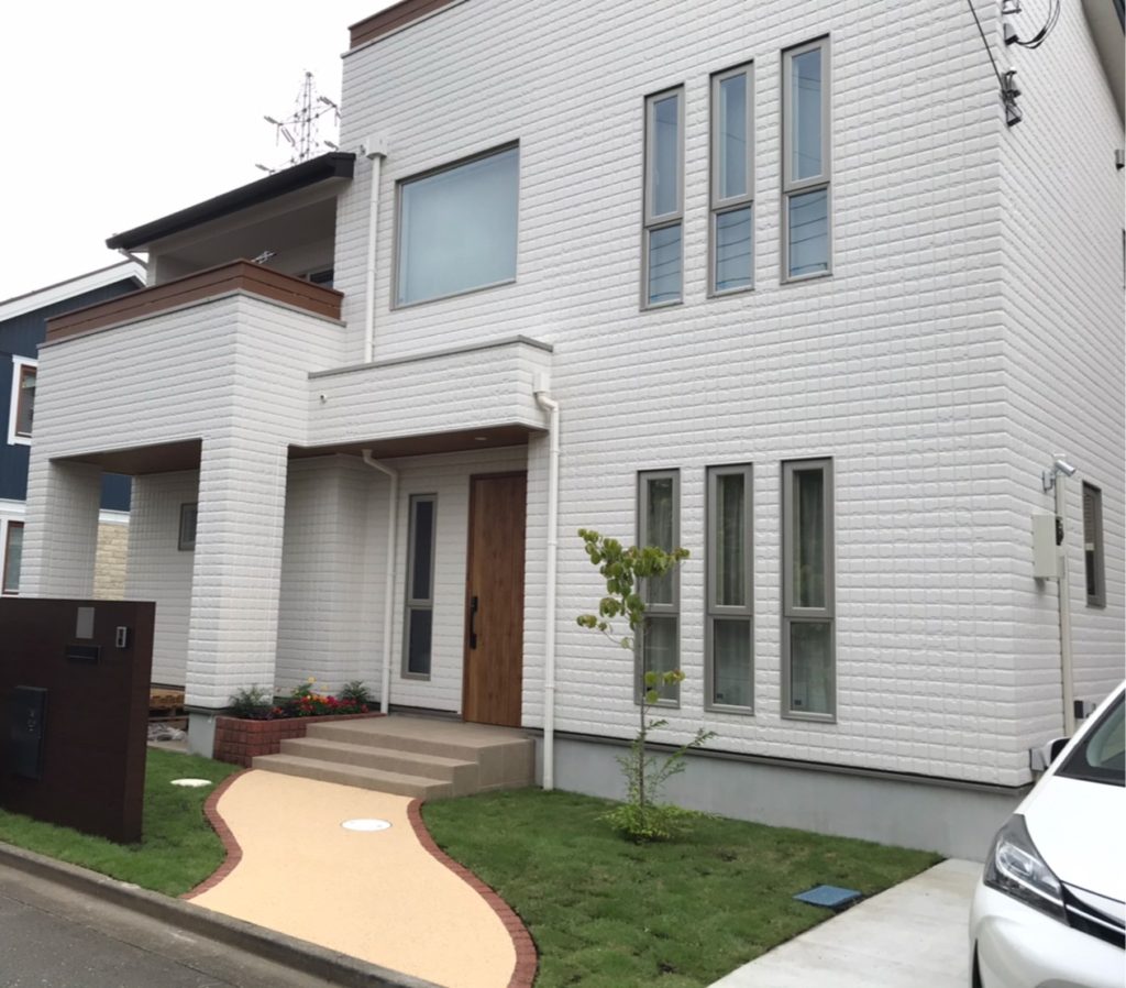 窓を大きくとり、光と風をたっぷりと招き入れる南側の外観。独特な土地形状を活かして、庭も広く確保できた。アメリカンフェンスもおしゃれ くふうイ