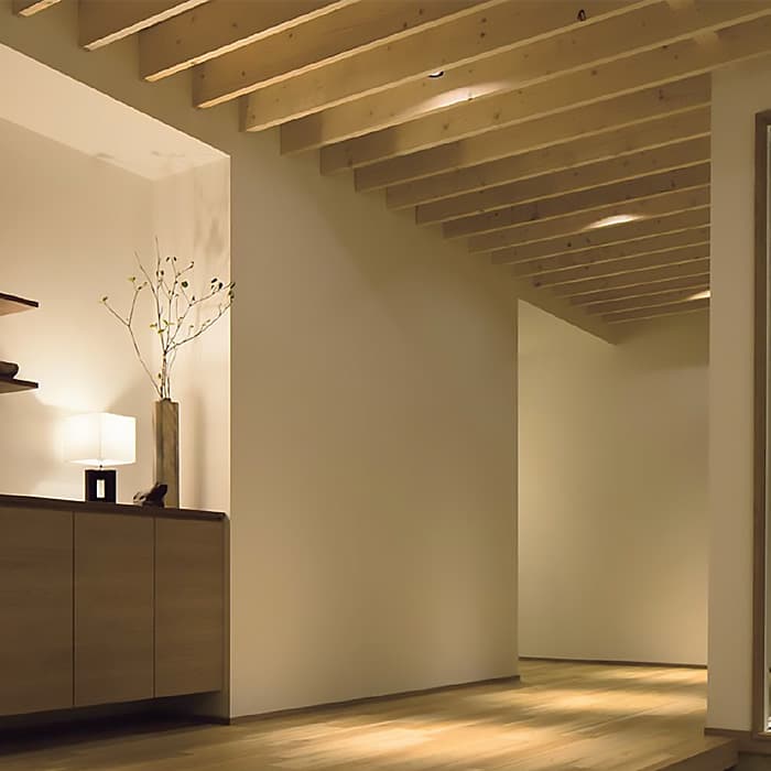 玄関からリビングに至る壁にも「ソリド」を採用し、内と外の一体感を強調。間接照明を用い、ホテルライクで洗練された雰囲気を演出。シューズクローク